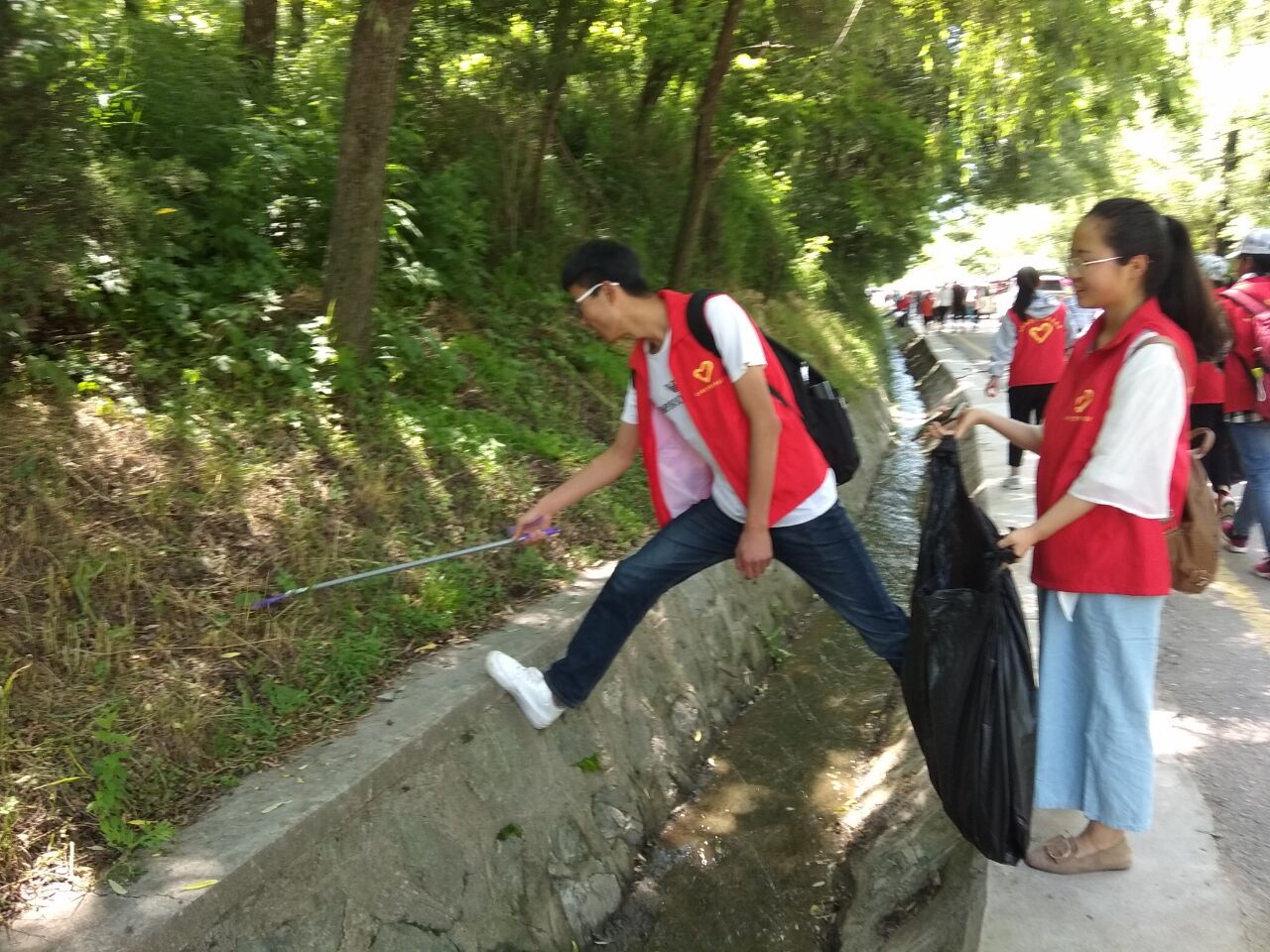 公司员工正在开展净化文化遗产景区环境志愿服务活动