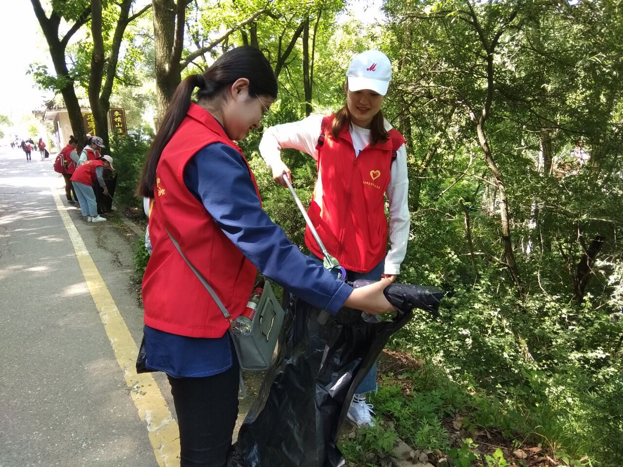 公司员工正在开展净化文化遗产景区环境志愿服务活动